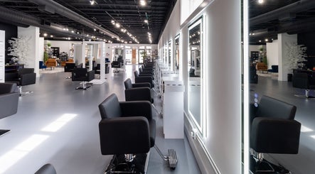 Modern salon interior at Studio LaSalle in DENTON, United States, US showcasing sleek black chairs and bright mirrors.