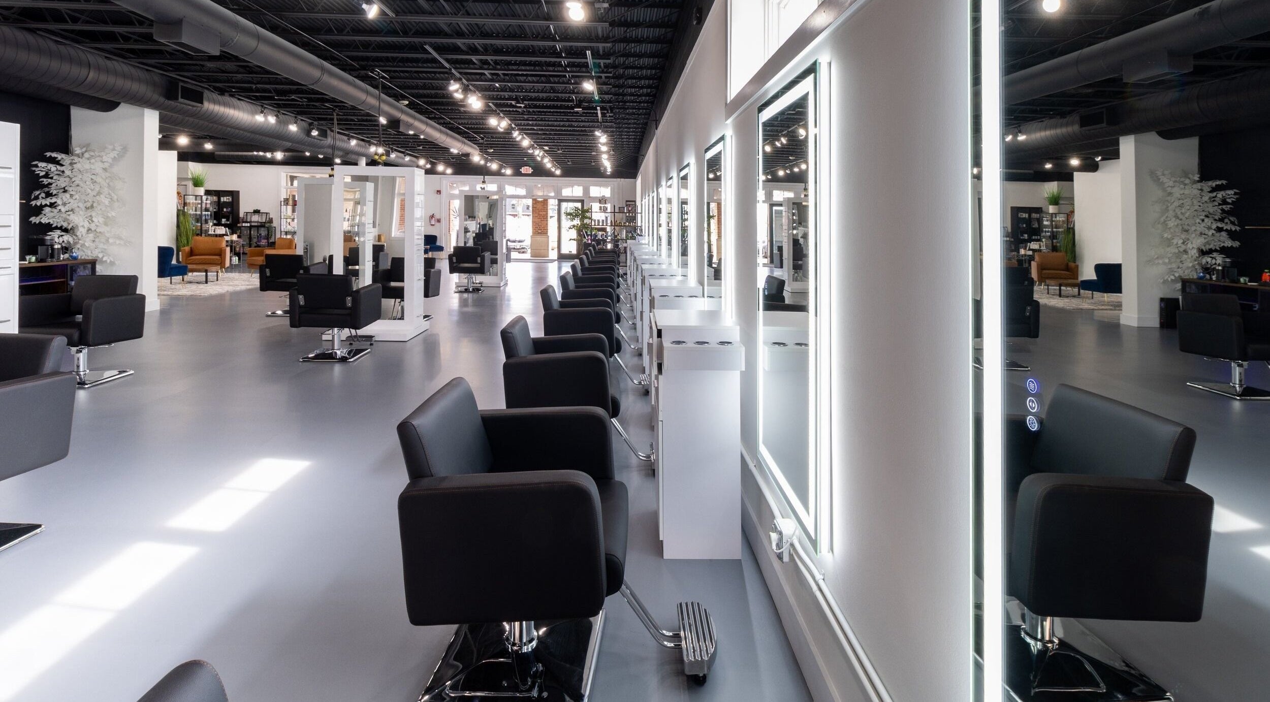 Modern salon interior at Studio LaSalle in DENTON, United States, US showcasing sleek black chairs and bright mirrors.