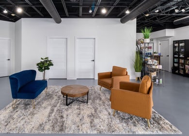 Modern seating area at Studio LaSalle, Denton, United States, US with navy and brown chairs on a textured rug.