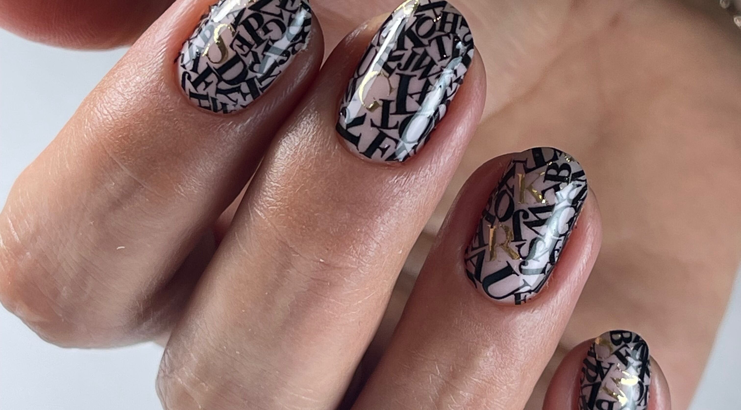 Close-up of letter-patterned nail art at Yasya Nails & Beauty, Bristol, Великобритания, GB.