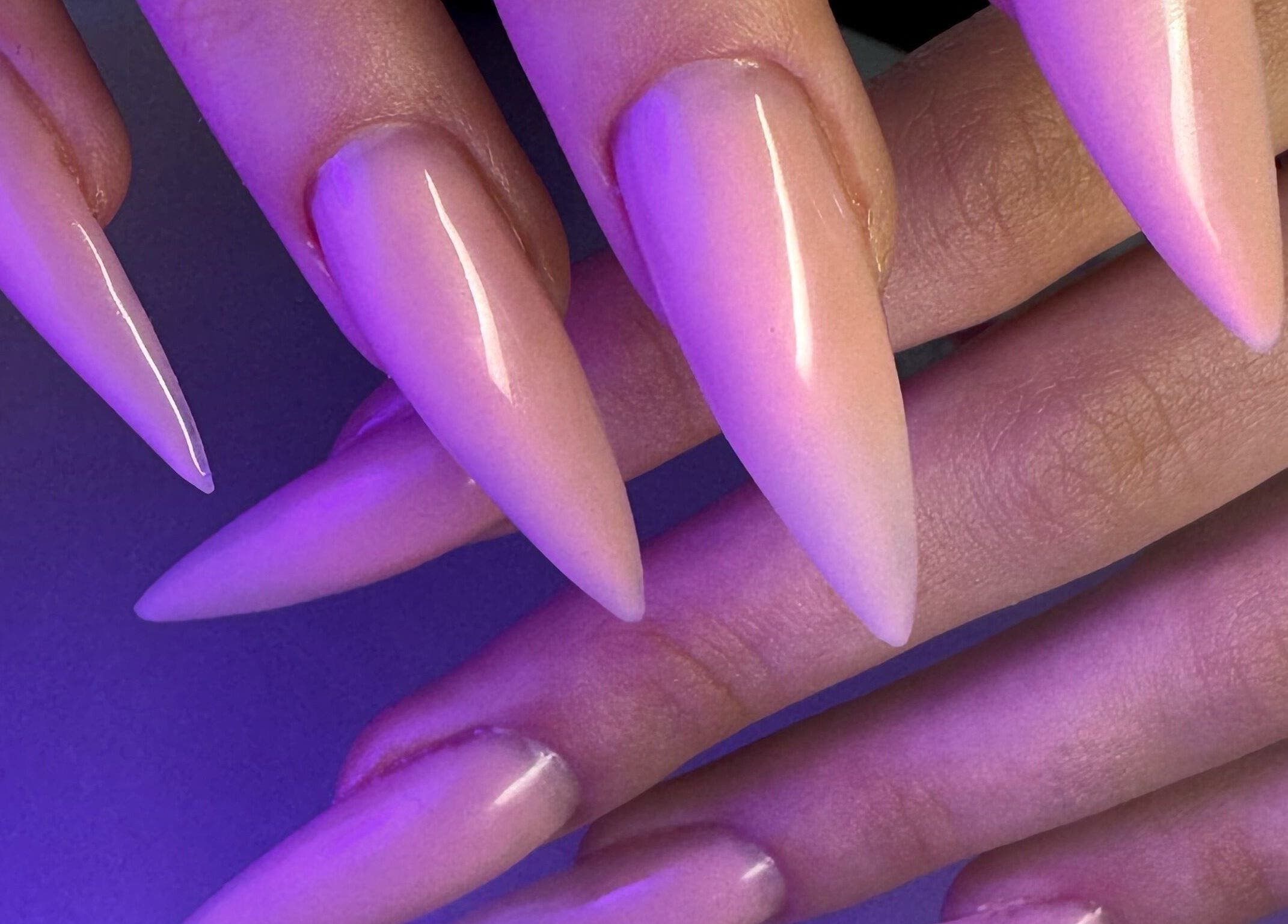 Elegant stiletto nails at Yasya Nails & Beauty, Bristol, Великобритания, GB under purple lighting.