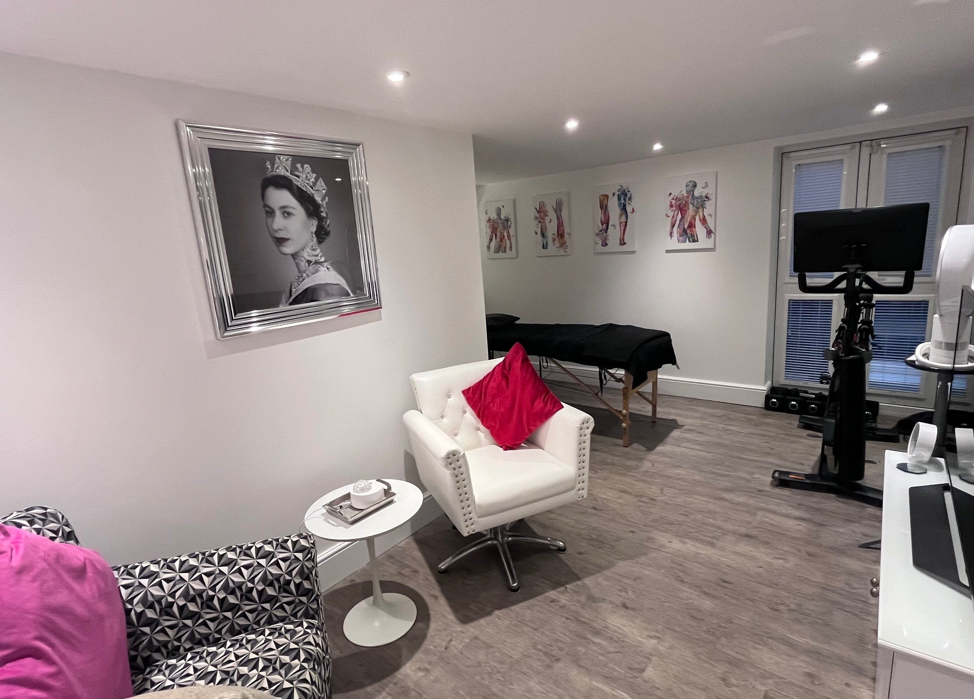 BodyLogic relaxation room with stylish decor in Higham Ferrers, GB, featuring modern art and a massage table.