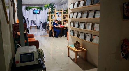 Interior de Estetica Sunflower en Aserri, San José, CR. Ambiente acogedor con plantas y diplomas en las paredes.