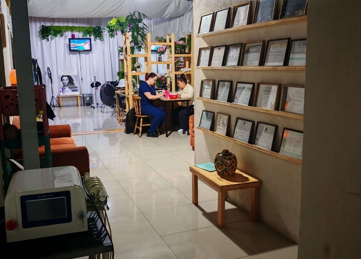 Interior acogedor de Estetica Sunflower, Aserri, San José, CR, mostrando diplomas y servicio en curso.