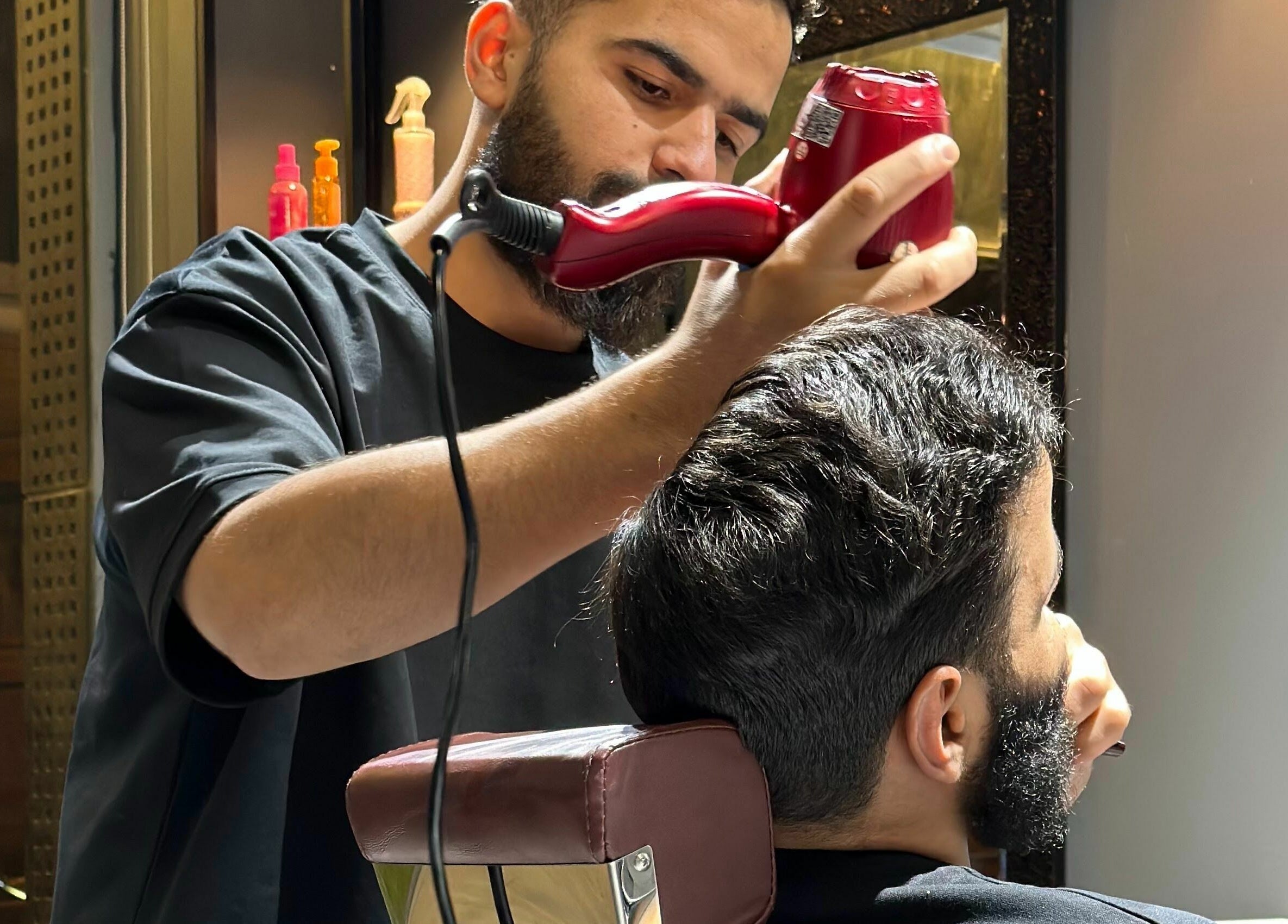 Barber styling hair at NjM Barbershop - النجم الخفي للحلاقة, Riyadh, Riyadh Province, SA. Professional grooming.