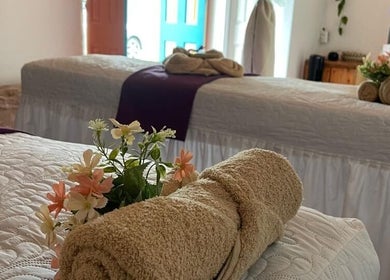 Camas de terapia en Sense Spa, Salento, Quindío, CO, decoradas con toallas y flores frescas.