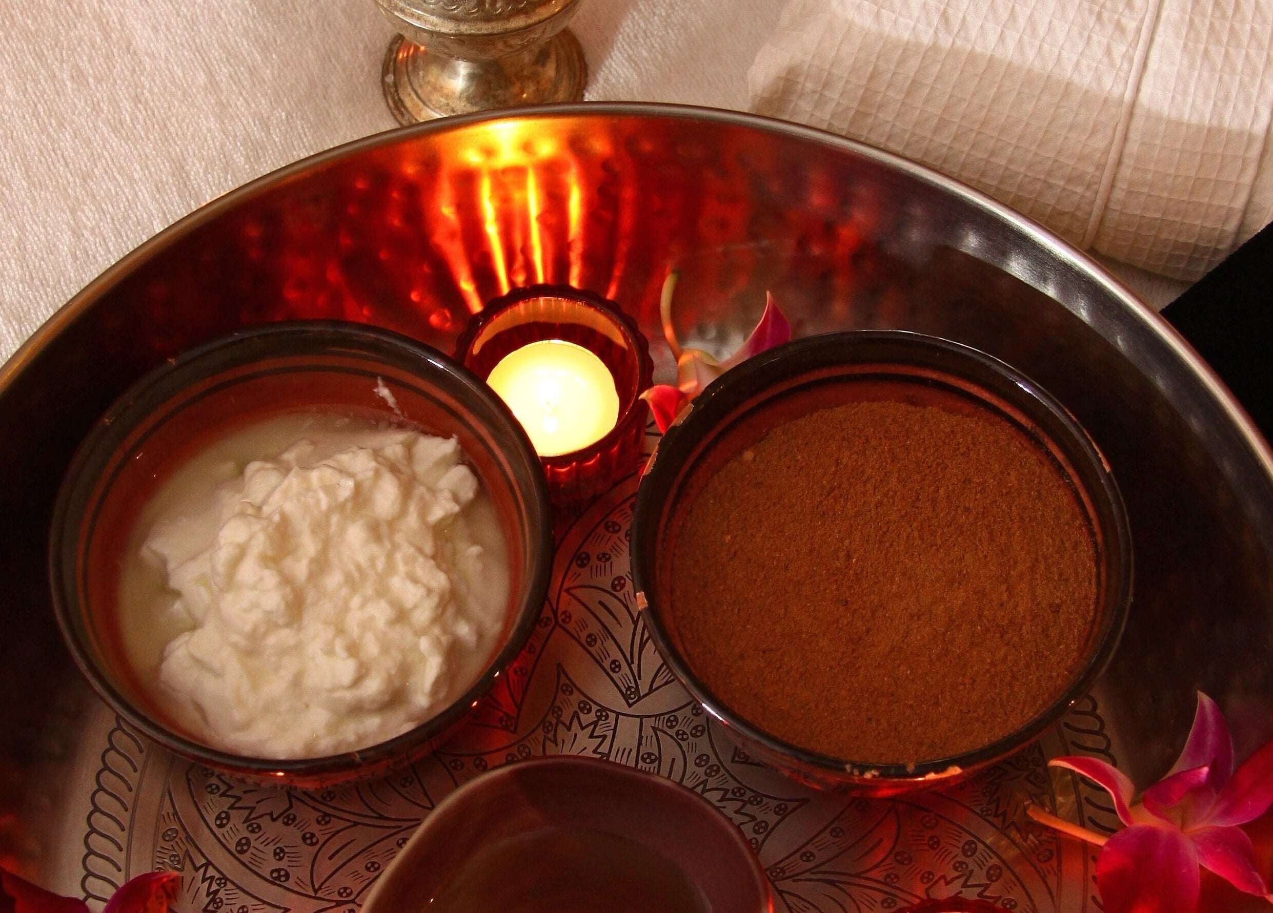 Ayana Spa Muscat in Muscat, OM offers a relaxing spa tray with candles and natural ingredients.