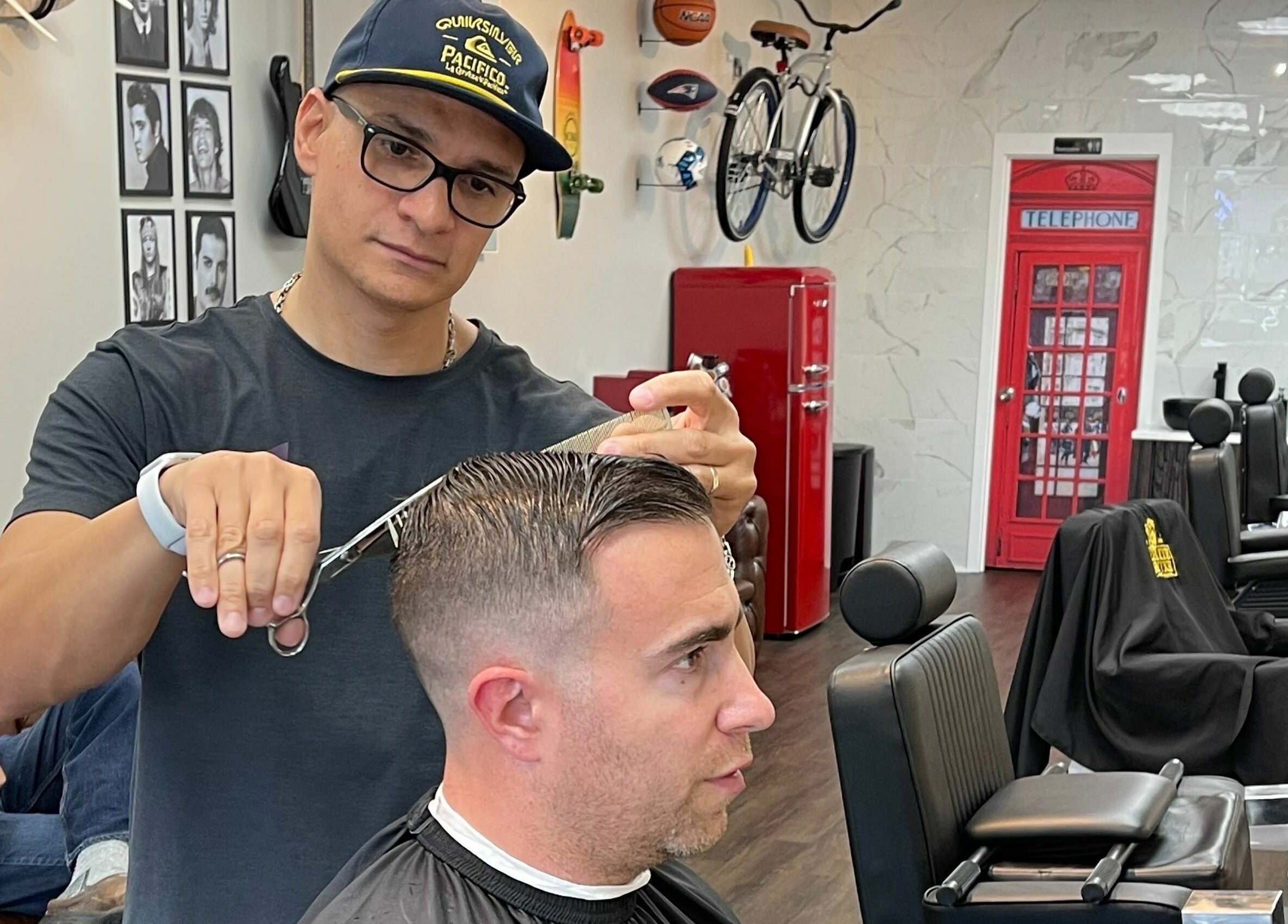 Barber expertly cuts hair at Art Zone Barbering, Massachusetts, US, in a stylish, modern setting.