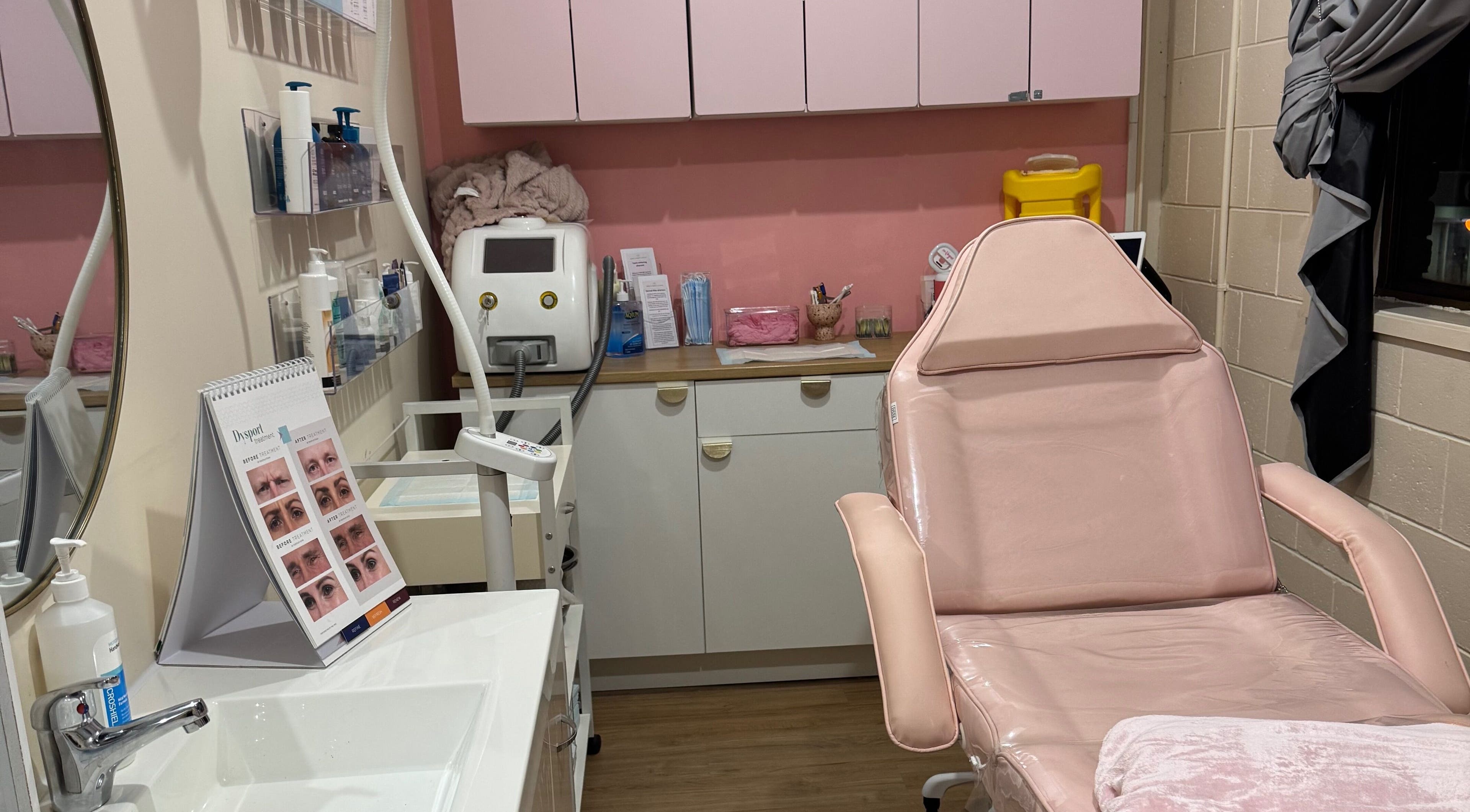 Luxury treatment room at Maddi's Cosmetic Clinique, Melbourne, Victoria, AU with pink accents and sleek decor.