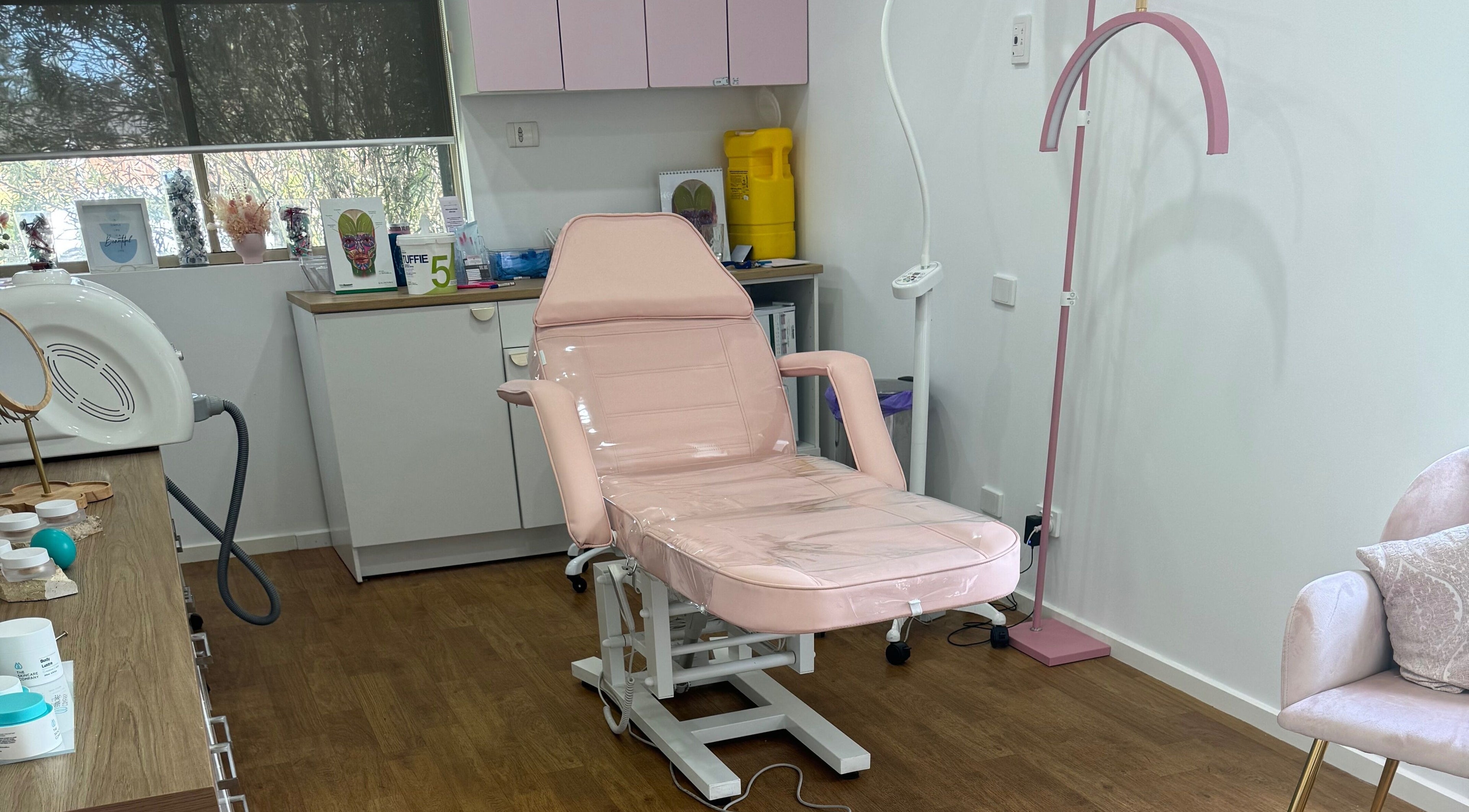Modern treatment room at Maddi's Cosmetic Clinique in Melbourne, Victoria, AU, featuring a comfy pink chair.
