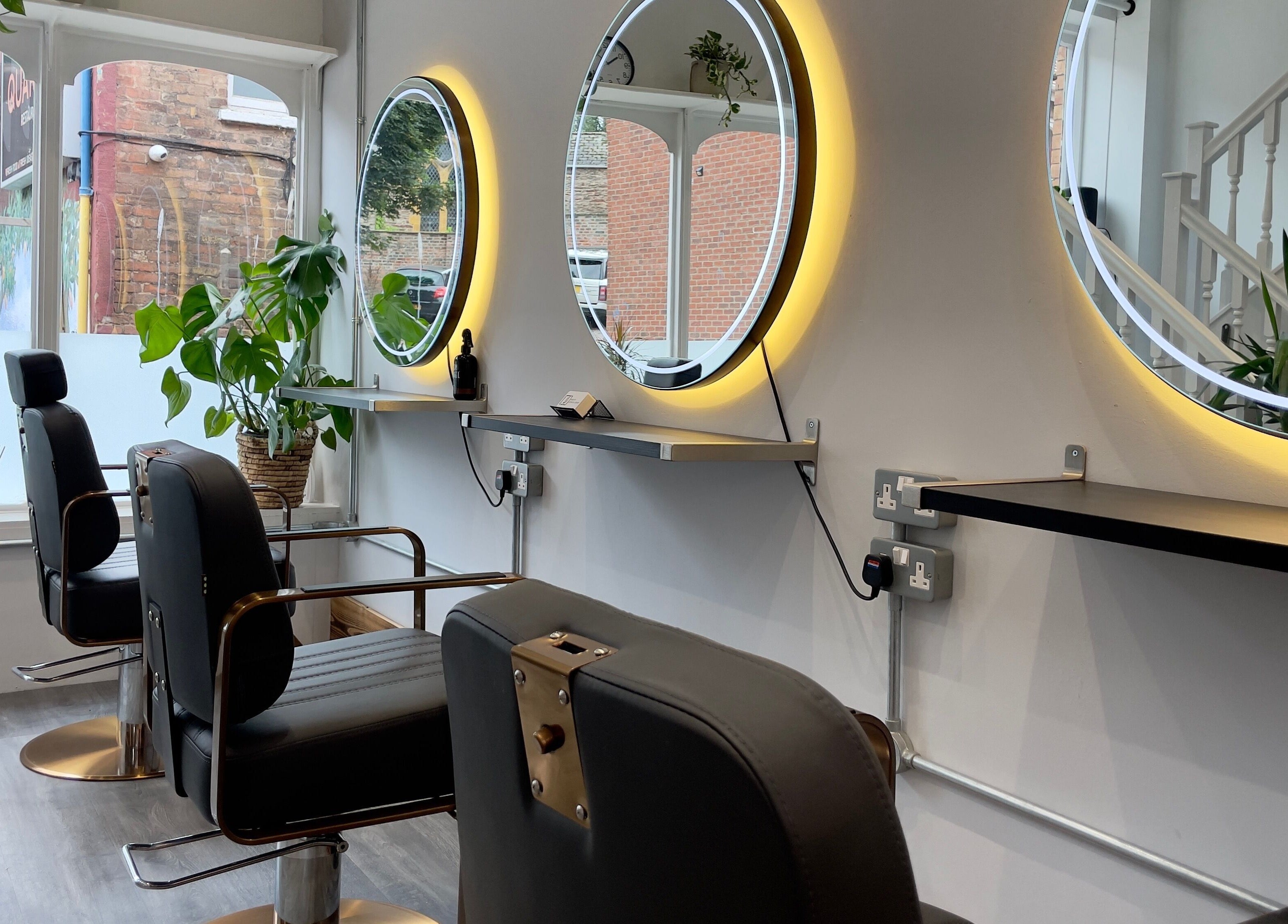 Modern salon interior with circular mirrors and stylish chairs at HAIR By Joshua Jones, Taunton, England, GB.