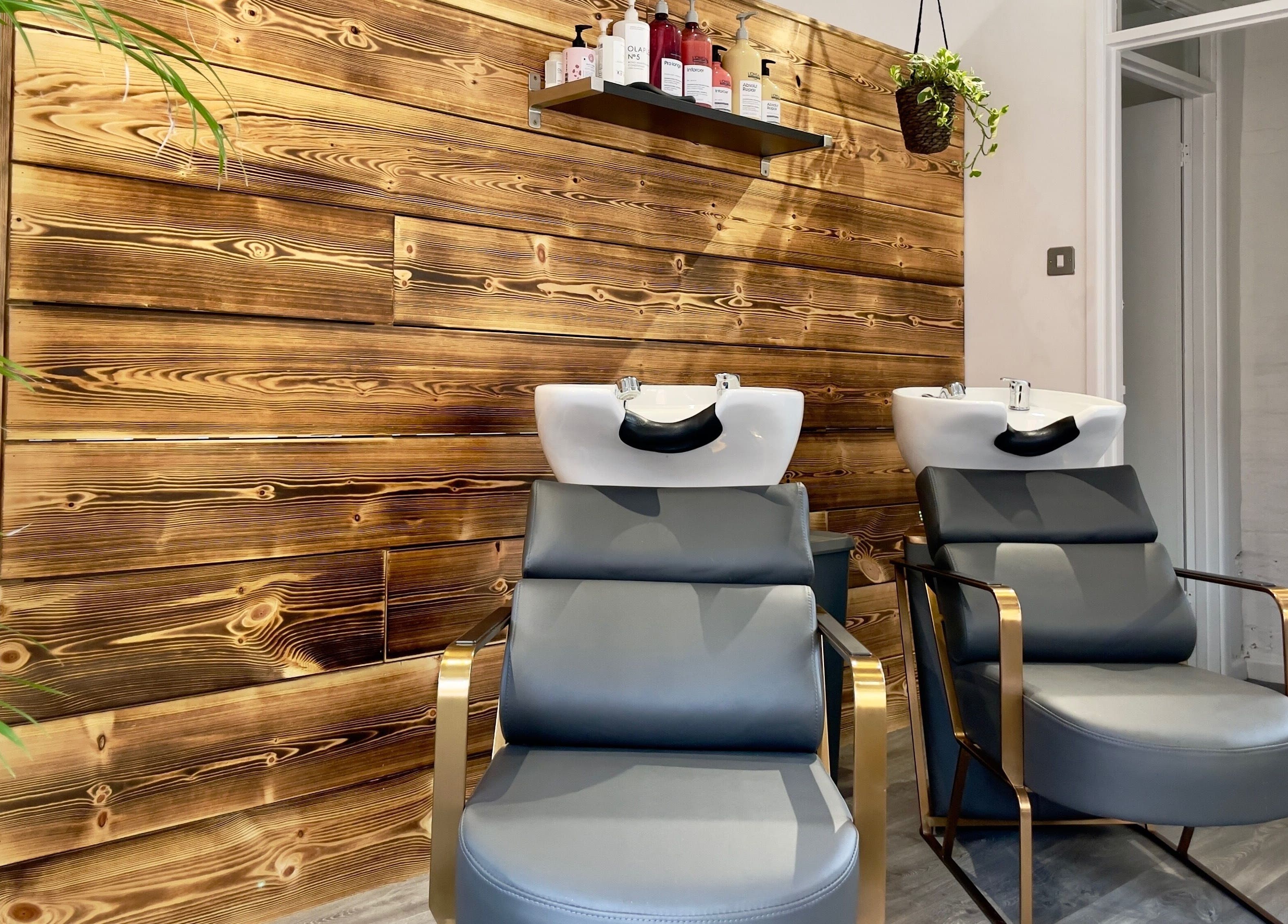 Modern wash stations at HAIR By Joshua Jones, Taunton, England, GB with wood accent wall.