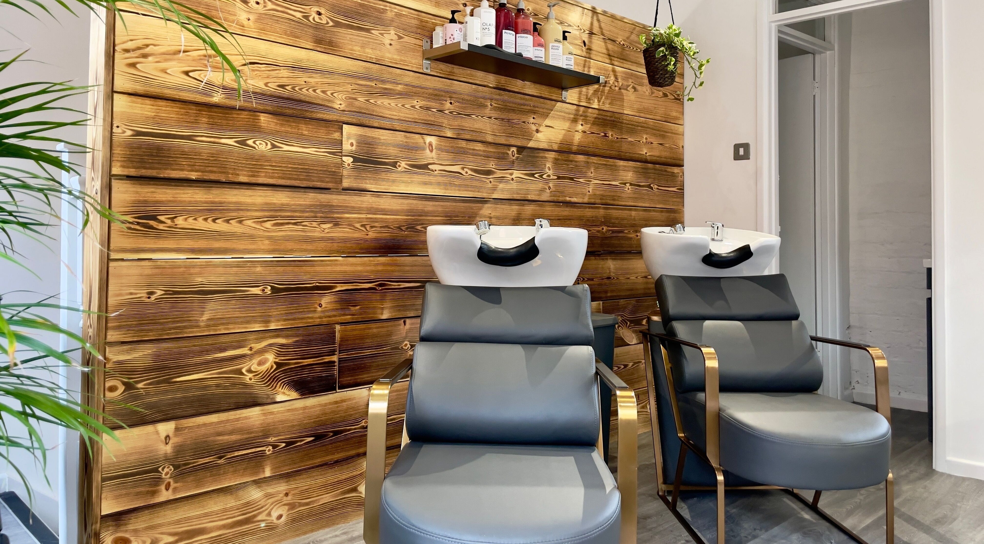 Modern wash stations at HAIR By Joshua Jones, Taunton, England, GB with wood accent wall.