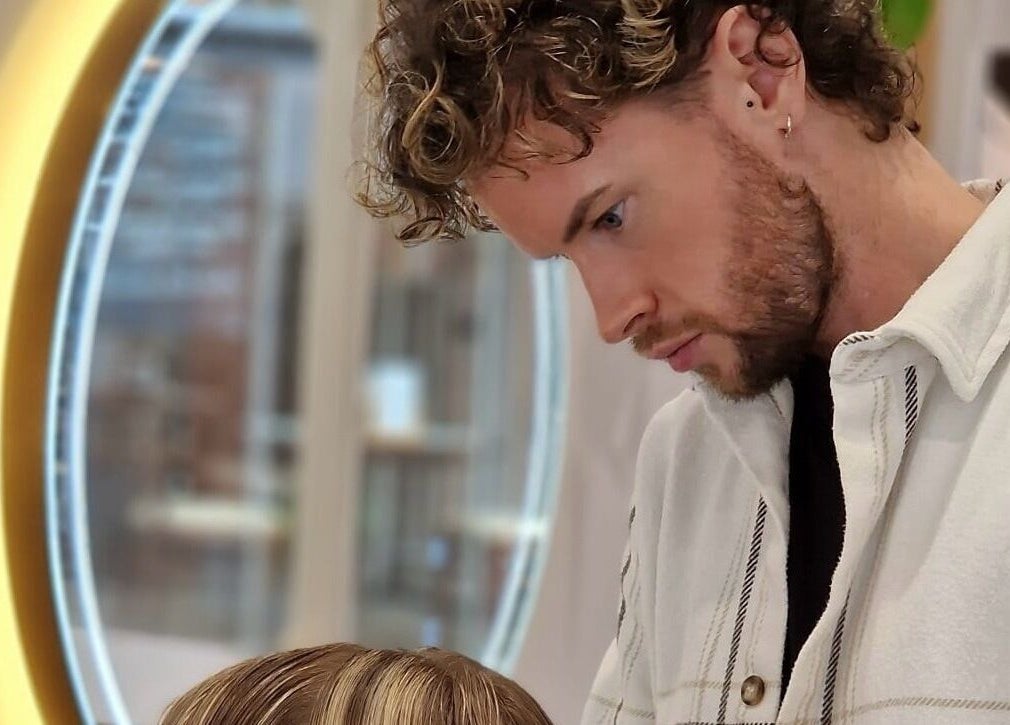 Stylist at HAIR By Joshua Jones in Taunton, England, GB, giving a haircut in a modern salon setting.