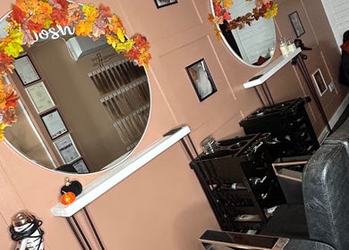 Stylish salon chairs and round mirrors with autumn leaves at Josh’s Hair Hideaway, Leicester, England, GB.