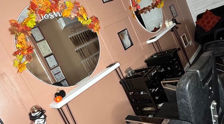Stylish salon chairs and round mirrors with autumn leaves at Josh’s Hair Hideaway, Leicester, England, GB.