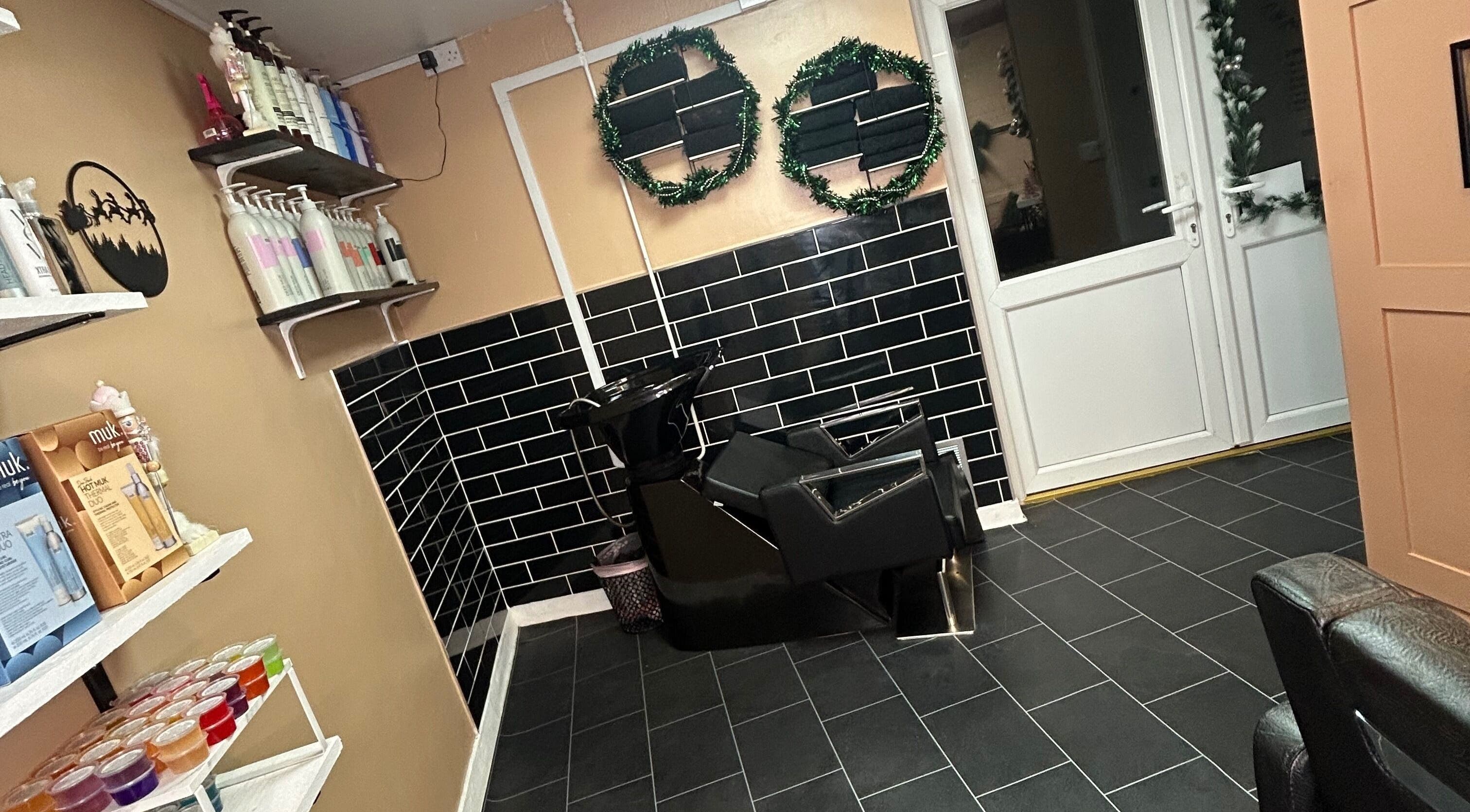 Salon interior at Josh’s Hair Hideaway, Leicester, England, featuring a sleek wash station and stylish shelves.