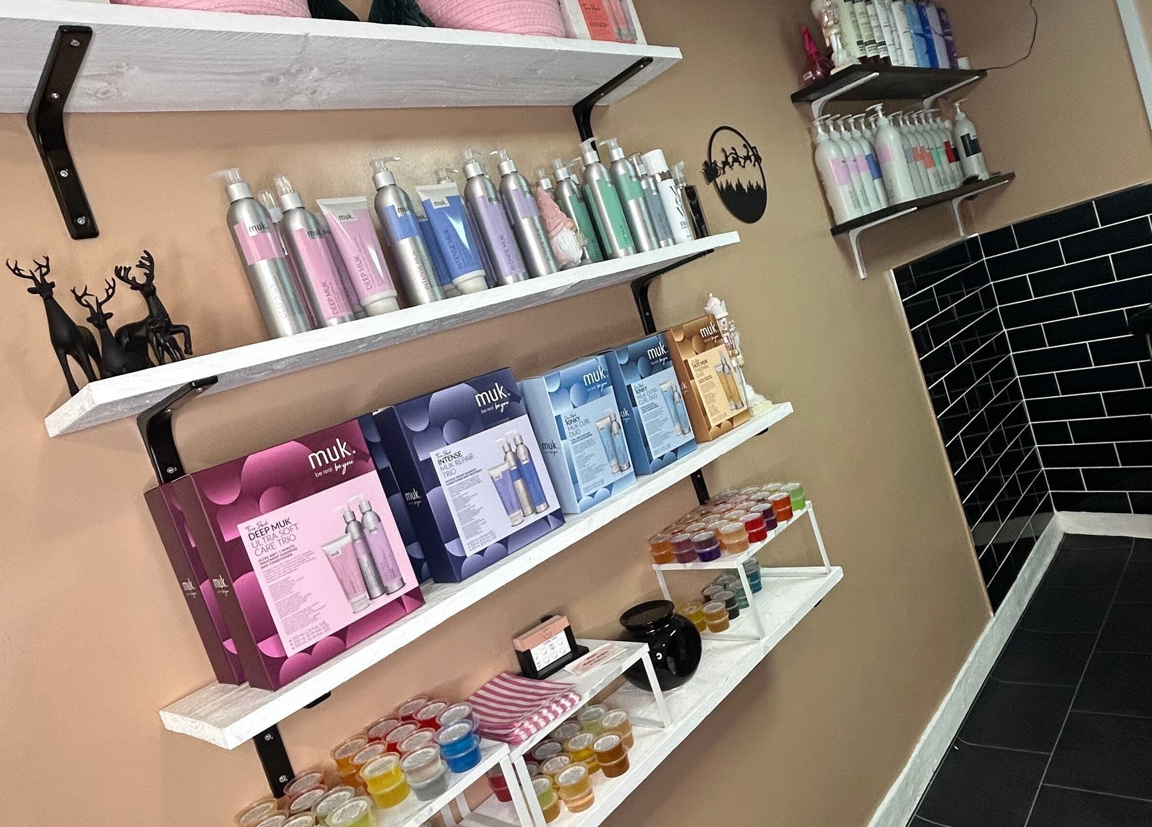 Product shelves at Josh’s Hair Hideaway, Leicester, England, with haircare items and elegant decor.