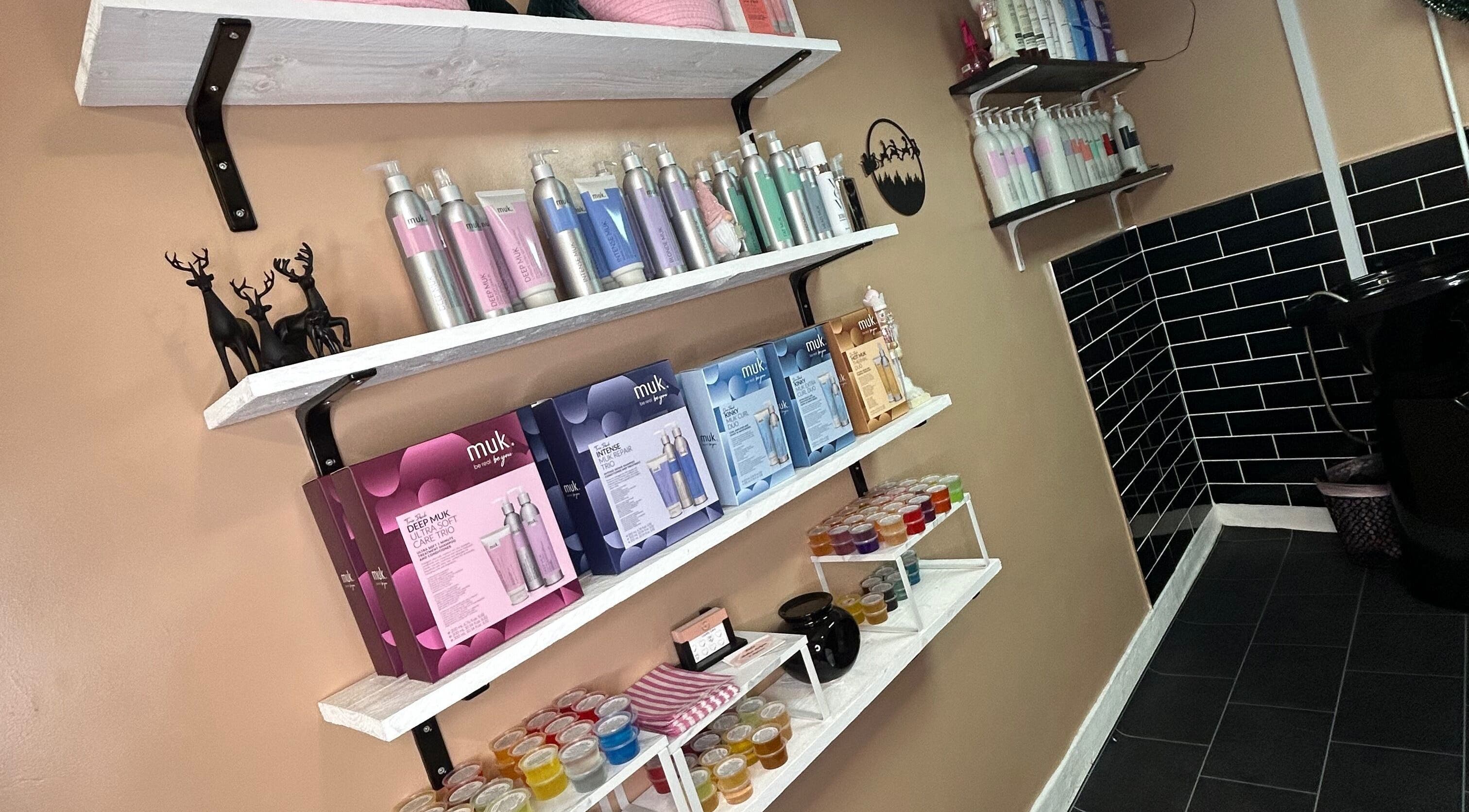 Product shelves at Josh’s Hair Hideaway, Leicester, England, with haircare items and elegant decor.