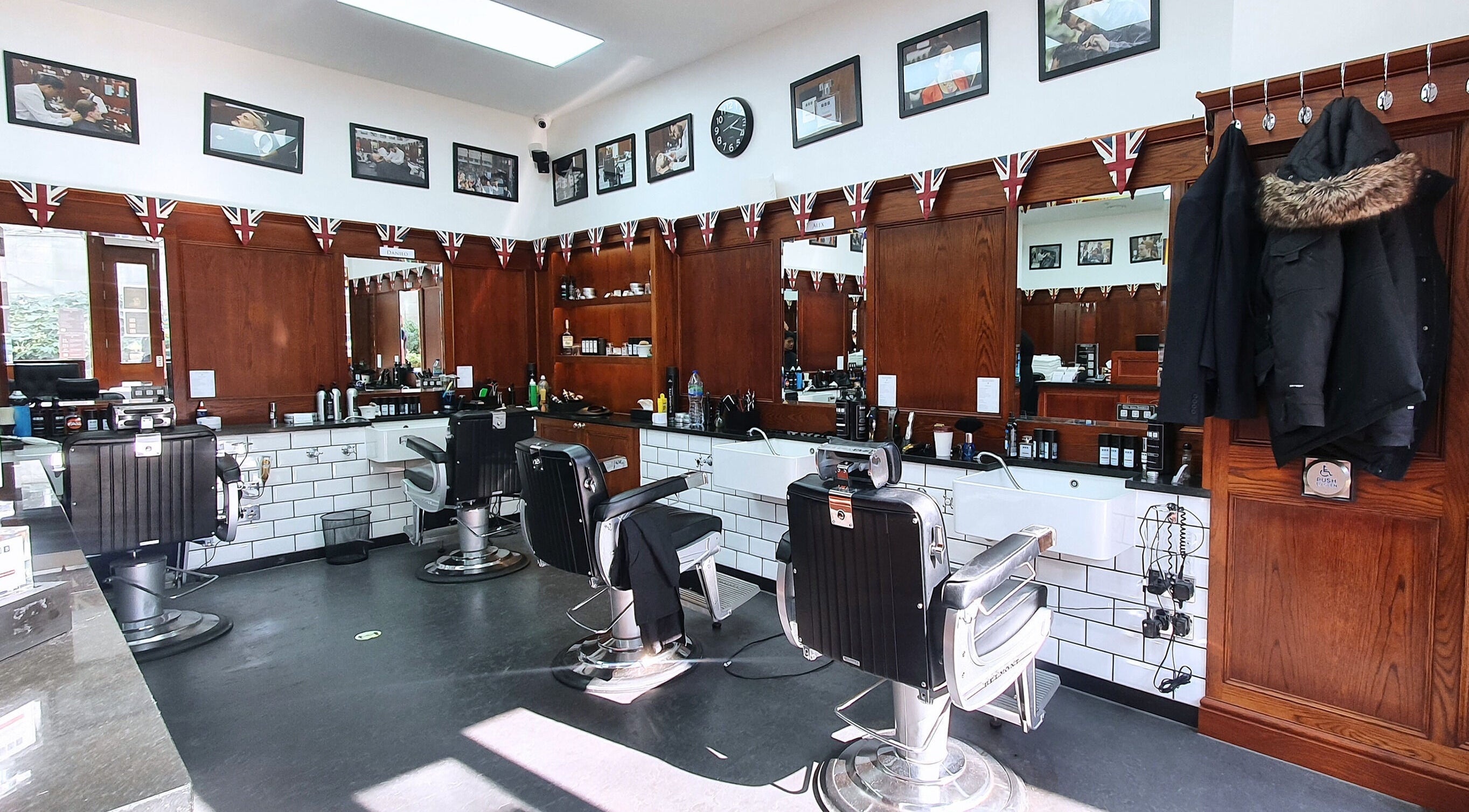 Interior of Pall Mall Barbers Paddington in London, England, GB, featuring sleek chairs and classic decor.