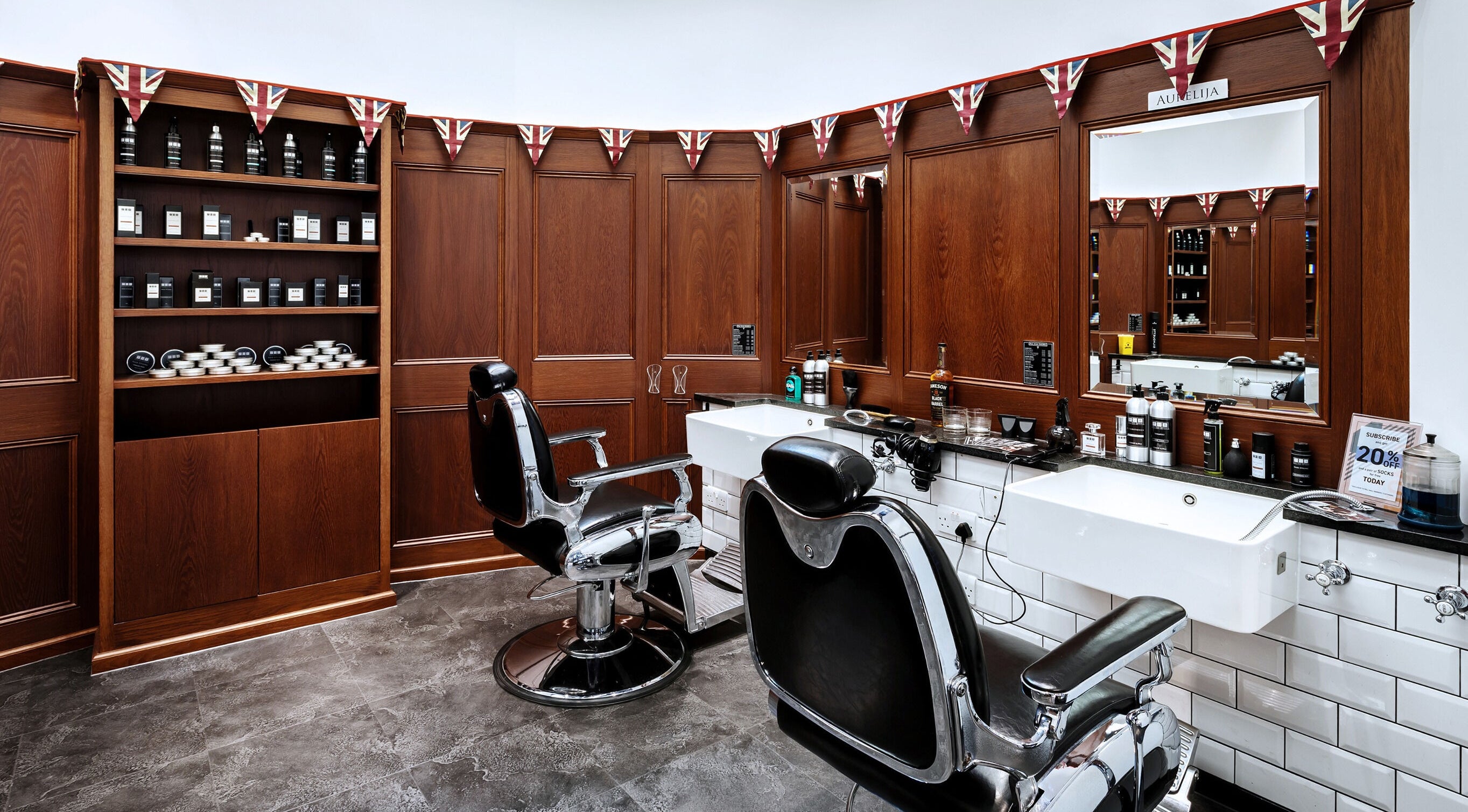 Cozy interior of Pall Mall Barbers Oxford Circus in London, England, GB with classic chairs and grooming products.