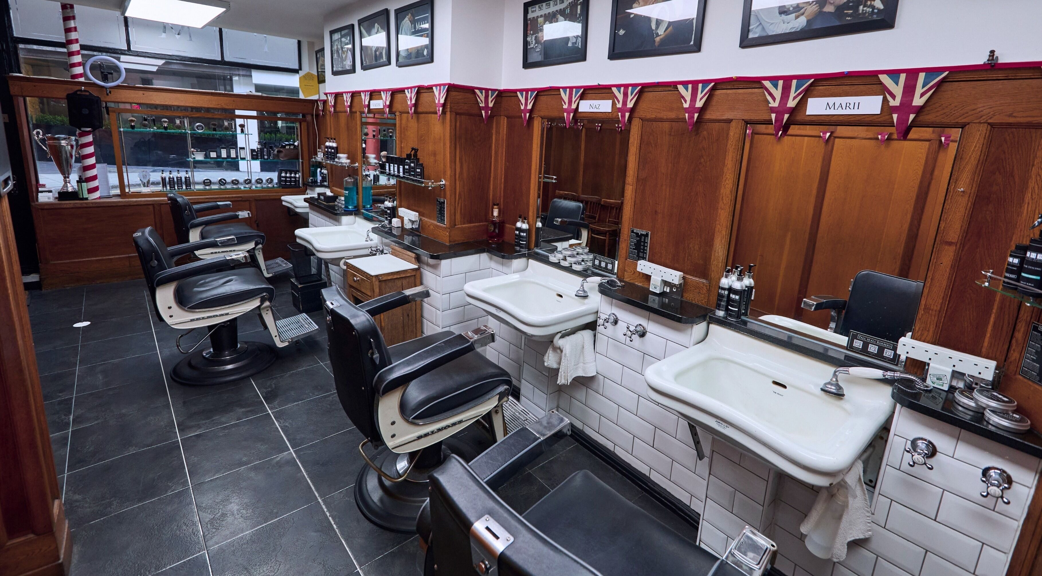 Interior of Pall Mall Barbers Trafalgar Square in London, England, featuring leather chairs and vintage decor.