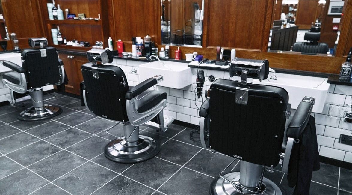 Elegant barber chairs at Pall Mall Barbers Kings Cross, London, England, GB, set against a classic interior.