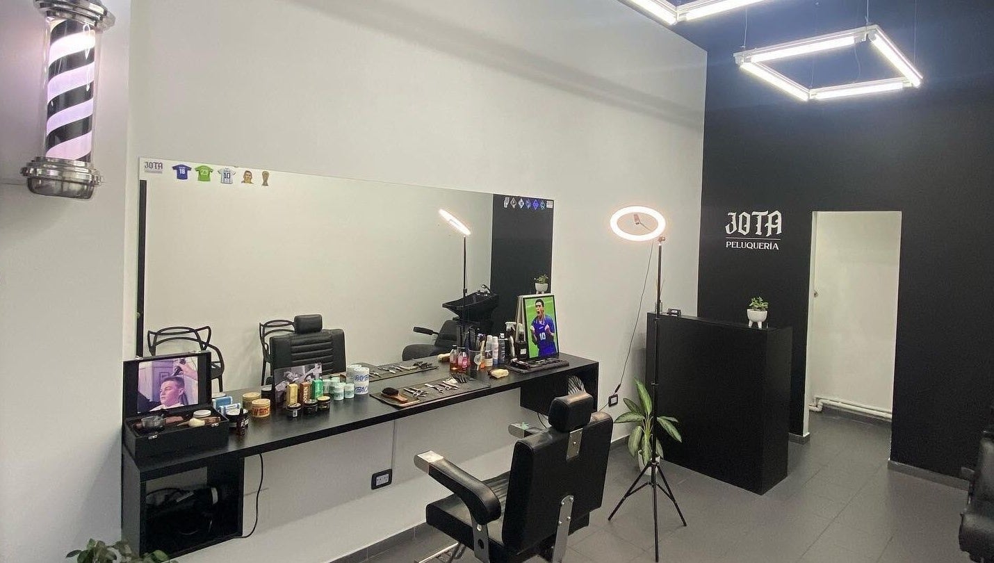 Interior de Jota Studio, Bahía Blanca, mostrando asientos de peluquería y productos organizados.