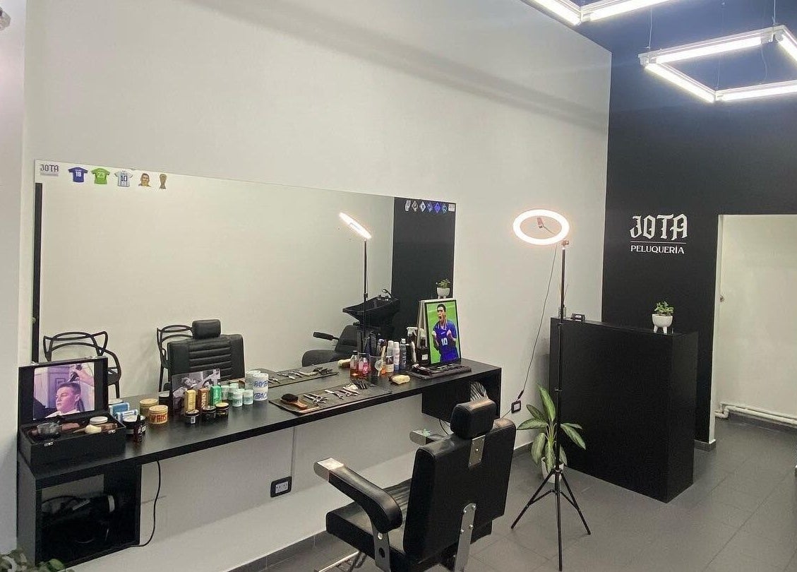 Interior de Jota Studio, Bahía Blanca, mostrando asientos de peluquería y productos organizados.