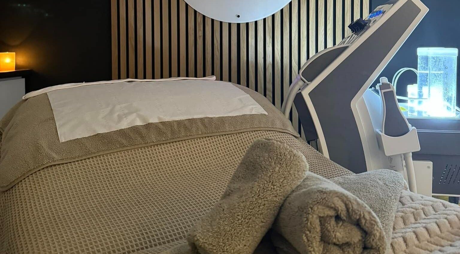 Relaxing spa bed with warm towels at The Beauté Spot, Ampthill, England, GB, featuring modern beauty equipment.