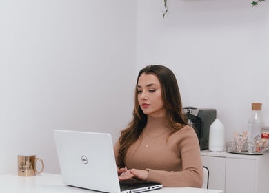 Woman at desk in Keila Kugnharski Aesthetic, Dublin, County Dublin, IE, working on a laptop.