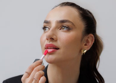 Woman applying lipstick at Keila Kugnharski Aesthetic in Dublin, County Dublin, IE, highlighting beauty services.