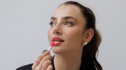 Woman applying lipstick at Keila Kugnharski Aesthetic in Dublin, County Dublin, IE, highlighting beauty services.