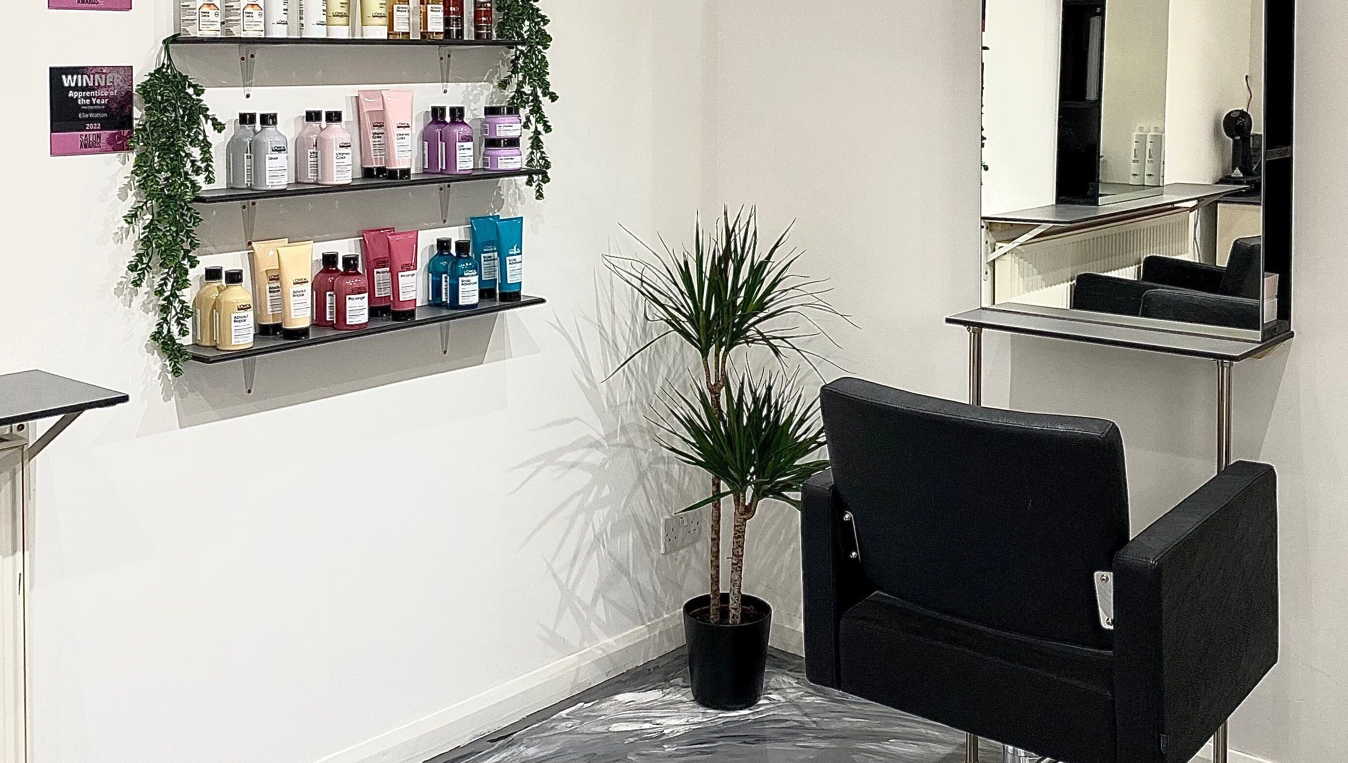 Elegant styling station at Eclipse Hair Salon, Houghton Regis, England, with product shelves and a mirror.