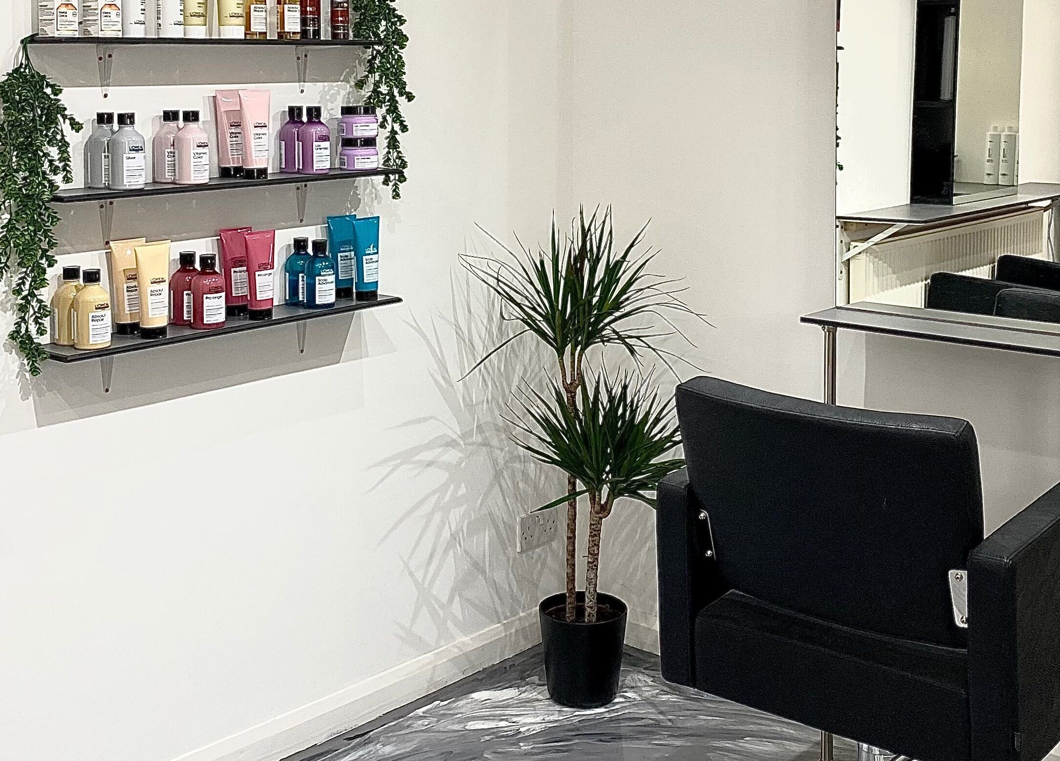 Elegant styling station at Eclipse Hair Salon, Houghton Regis, England, with product shelves and a mirror.