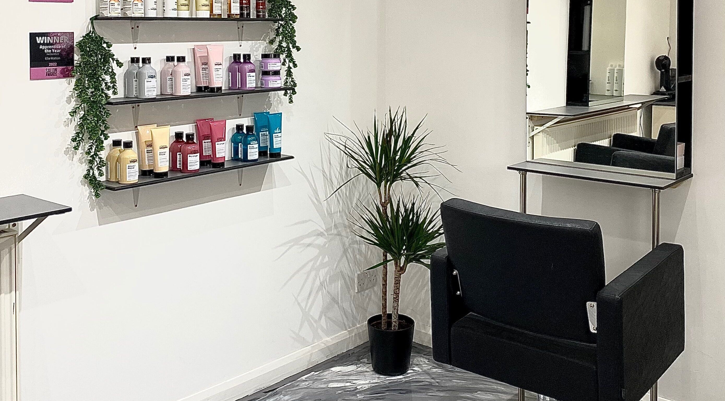 Elegant styling station at Eclipse Hair Salon, Houghton Regis, England, with product shelves and a mirror.