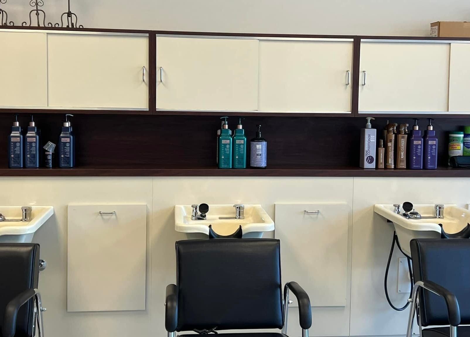 Shampoo stations at The A Salon and Spa in Lyman, South Carolina, US, featuring modern black chairs.