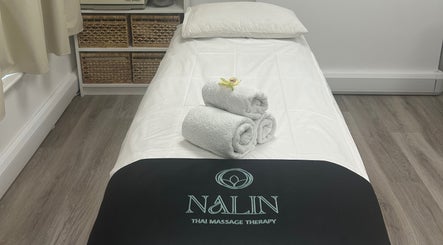 Massage bed at Nalin Thai Massage Therapy in Derby, England, GB with towels and orchid for relaxation.