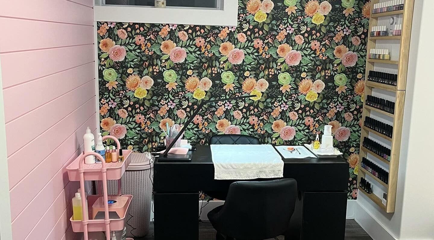 Chic nail salon interior at Nail Design by Megan, Fenelon Falls, Ontario, CA with floral wall and manicure station.