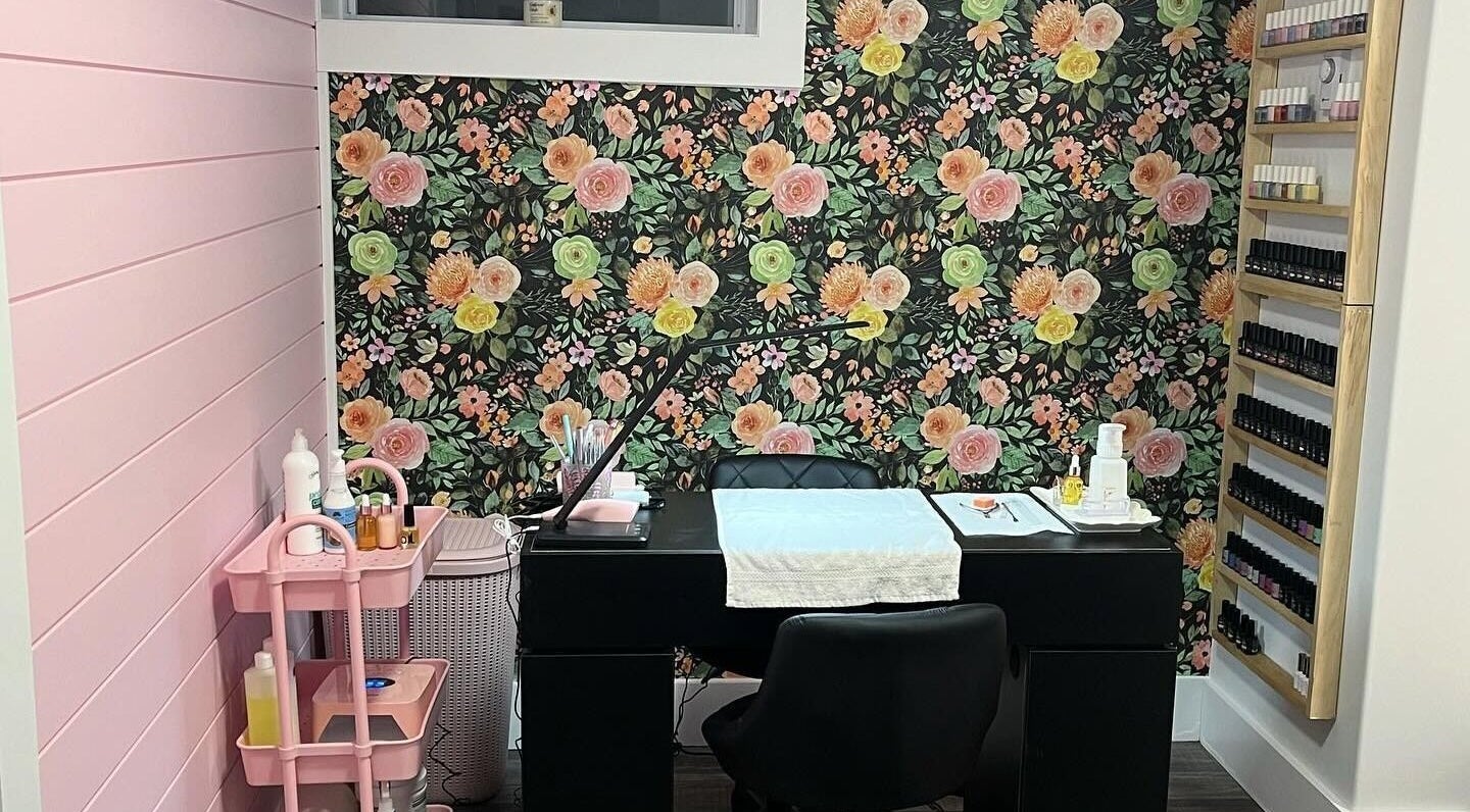 Chic nail salon interior at Nail Design by Megan, Fenelon Falls, Ontario, CA with floral wall and manicure station.