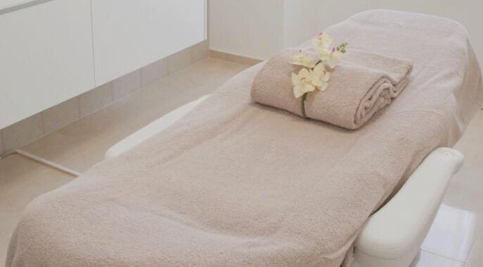 Relaxing spa treatment bed at Brisbane Tans and Beauty, Lawnton, Queensland, AU, with flowers and towels.