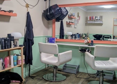 Stylish salon interior at Awesome Hair Is, Eagleby, Queensland, AU, featuring modern chairs and product display.