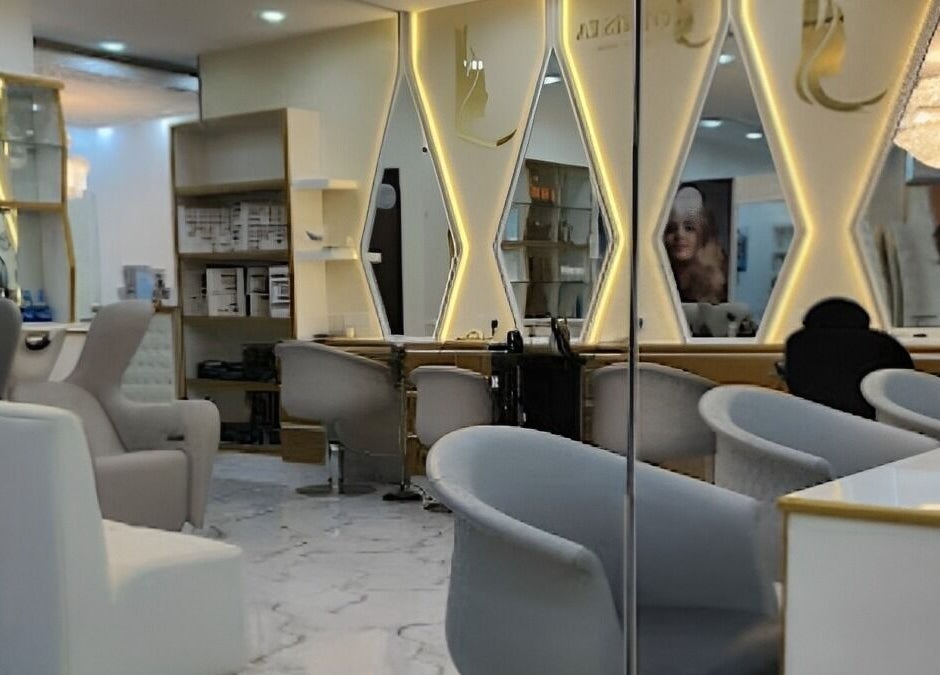 Interior of Rebo Beauty Salon, Dubai, AE, featuring elegant mirrored walls and modern salon chairs.
