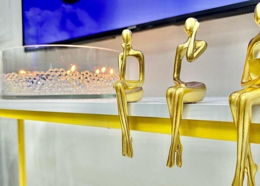 Sleek golden figurines and candle display at Rebo Beauty Salon, Dubai, AE add a touch of elegance.