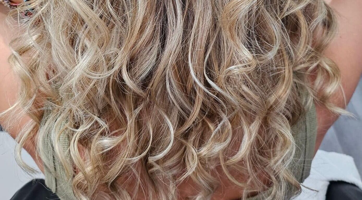 Cabelo loiro ondulado em destaque no Studio Isabela, Portimão, Faro, PT. Beleza natural e brilho impecável.