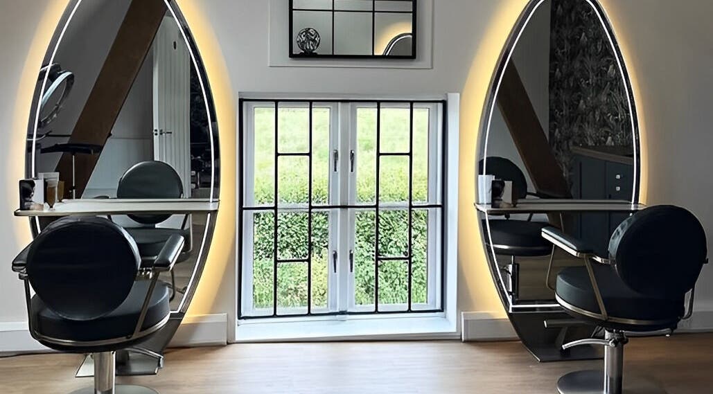 Sleek styling stations with oval mirrors at Anthony James, Pattingham, GB, create a modern and inviting salon atmosphere.