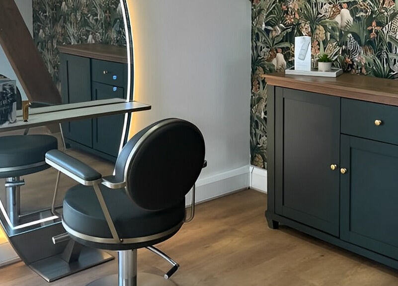 Elegant salon station at Anthony James, Pattingham, GB with modern chair and illuminated mirror.