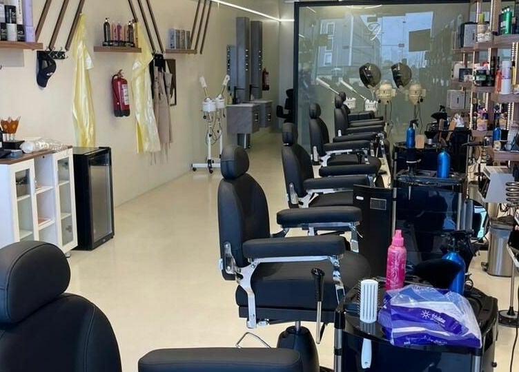 Elegant interior of Trendy Cut | Al Qirawan salon in Riyadh, Riyadh Province, SA featuring modern chairs and styling stations.