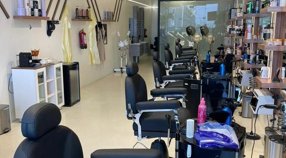 Elegant interior of Trendy Cut | Al Qirawan salon in Riyadh, Riyadh Province, SA featuring modern chairs and styling stations.