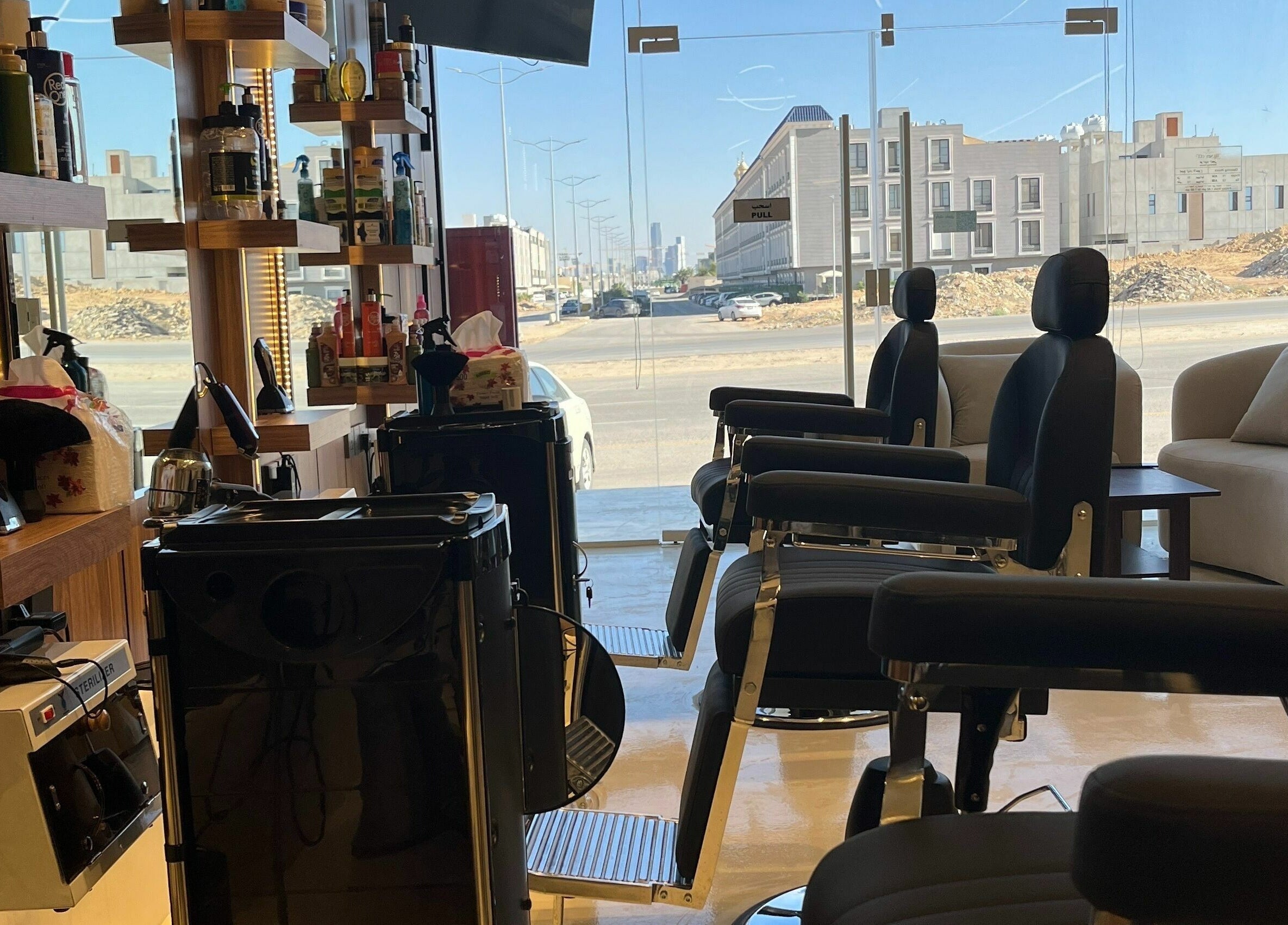 Modern decor of Trendy Cut | Al Qirawan in Riyadh, Riyadh Province, SA. Sleek chairs and stylish shelving enhance ambiance.